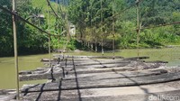 Hampir semua kayu yang digunakan sebagai pijakan kaki di jembatan hilang dan beberapa kawat bajanya juga mulai terlepas.
