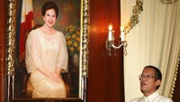 Benigno Noynoy Aquino berada disamping potret ibunya, Corazon Aquino di Istana Kepresidenan, tak lama setelah ia dilantik, di Manila, Filipina (30/6/2010). Corazon bersama suaminya, Benigno Simeon Aquino Jr  merupakan tokoh yang menggulingkan diktator Ferdinand Marcos. Foto: AP/Rolex Dela Pena