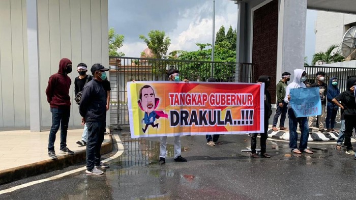 Pedemo bawa spanduk gambar Gubernur Riau, Syamsuar, yang diedit menjadi drakula (Raja Adil-detikcom)