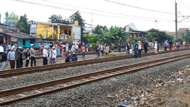 Pendukung HRS berkerumun di rek kereta dekat Stasiun Klender