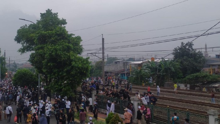 Pendukung HRS berkerumun di rek kereta dekat Stasiun Klender