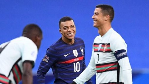 Frances forward Kylian Mbappe (C) shares a laugh with Portugals forward Cristiano Ronaldo during the Nations League football match between France and Portugal, on October 11, 2020 at the Stade de France in Saint-Denis, outside Paris. (Photo by FRANCK FIFE / AFP)