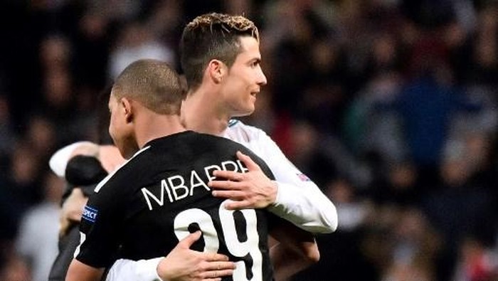 Real Madrids Portuguese forward Cristiano Ronaldo (R) hugs Paris Saint-Germains French forward Kylian Mbappe during the UEFA Champions League round of sixteen first leg football match Real Madrid CF against Paris Saint-Germain (PSG) at the Santiago Bernabeu stadium in Madrid on February 14, 2018. (Photo by CHRISTOPHE SIMON / AFP)