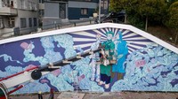Seniman jalanan membuat mural bertema virus corona skala besar di Istanbul, Turki (31/7/2020).  Chris McGrath/Getty Images