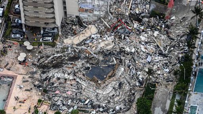 This aerial view, shows search and rescue personnel working on site after the partial collapse of the Champlain Towers South in Surfside, north of Miami Beach, on June 24, 2021. - The multi-story apartment block in Florida partially collapsed early June 24, sparking a major emergency response. Surfside Mayor Charles Burkett told NBCs Today show: My police chief has told me that we transported two people to the hospital this morning at least and one has died. We treated ten people on the site. (Photo by CHANDAN KHANNA / AFP)