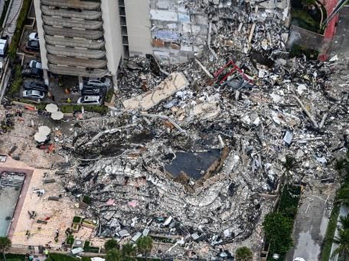 This aerial view, shows search and rescue personnel working on site after the partial collapse of the Champlain Towers South in Surfside, north of Miami Beach, on June 24, 2021. - The multi-story apartment block in Florida partially collapsed early June 24, sparking a major emergency response. Surfside Mayor Charles Burkett told NBCs Today show: My police chief has told me that we transported two people to the hospital this morning at least and one has died. We treated ten people on the site. (Photo by CHANDAN KHANNA / AFP)