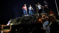 Masyarakat Venezuela ikut bersukacita memperingati 200 tahun perang kemerdekaan sambil menaiki kendaraan tempur usai parade militer. 