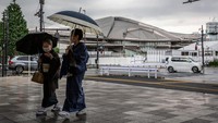 Dua orang wanita mengenakan Kimono berjalan melewati Tokyo Metropolitan Gymnasium di Tokyo, Jepang. Yuichi Yamazaki/Getty Images