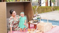 Di sebuah resort, Shandy dan buah hatinya tampak bahagia membagikan momen seru piknik mereka. Ada beragam camilan yang keduanya nikmati. Foto: Instagram @shandyaulia