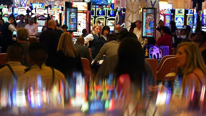 Operator judi asal Malaysia membuka kasino baru, Resorts World Las Vegas. Pengunjung datang tanpa masker maupun jaga jarak di masa pandemi global.
