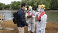 Dirut Plt. PT Kimia Farma Diagnostika Agus Chandra saat menjalani pemeriksaan suhu badan oleh petugas setibanya di Combo Dock Kilang Tangguh LNG, Senin (21/6/2021).