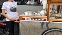 Posenya di depan gerobak bajigur ini jadi salah satu bukti kalau Tata sangat ingin minum bajigur saat hamil. Kali ini ngidam bajigur. Ya gitu, hamil ga hamil sukanya makanan kampung, aku tuh memang ndesooo, tulis Tata.  Foto: instagram @tatajaneetaOfficial