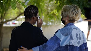 Janice yang emosional ditenangkan oleh seorang wanita yang tak teridentifikasi. Foto: AP/Joan Mateu