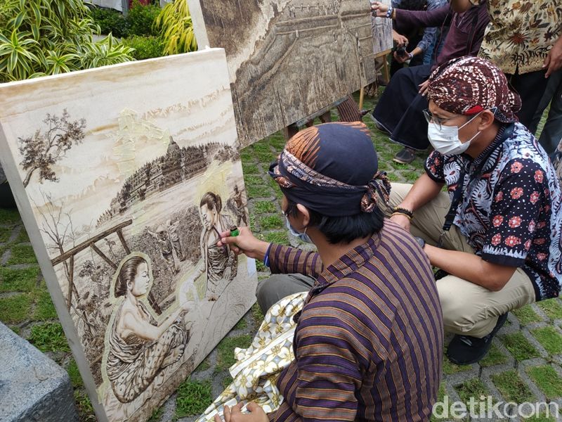 Wawan Geni saat menyelesaikan lukisan dengan pewarnaan obat nyamuk bakar