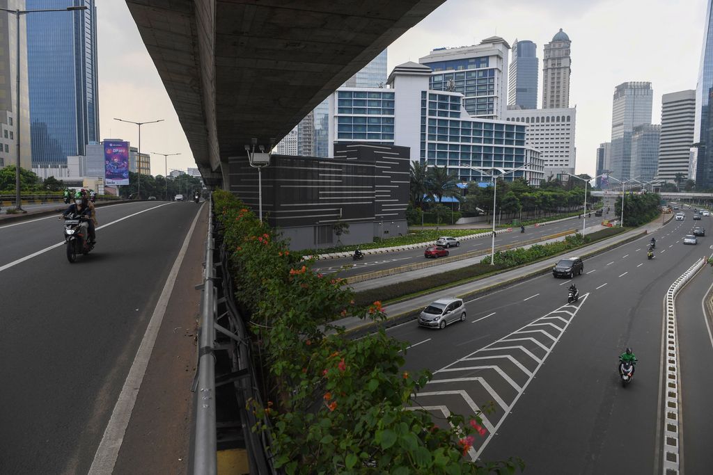 Pengendara melintasi kawasan jalan Sudirman yang lengang di Jakarta, Minggu (27/6/2021). Pembatasan kegiatan oleh pemerintah melalui PPKM Mikro hingga 5 Juli 2021 antara lain penutupan ruang publik, pembatasan operasional transportasi serta  penerapan protokol lebih ketat diharapkan dapat mengurangi penyebaran COVID-19 dimana fasilitas kesehatan telah penuh dalam menghadapi lonjakan pasien terkonfirmasi COVID-19. ANTARA FOTO/Wahyu Putro A/aww.