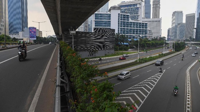 ANTISIPASI PENYEBARAN COVID-19 Pengendara melintasi kawasan jalan Sudirman yang lengang di Jakarta, Minggu (27/6/2021). Pembatasan kegiatan oleh pemerintah melalui PPKM Mikro hingga 5 Juli 2021 antara lain penutupan ruang publik, pembatasan operasional transportasi serta penerapan protokol lebih ketat diharapkan dapat mengurangi penyebaran COVID-19 dimana fasilitas kesehatan telah penuh dalam menghadapi lonjakan pasien terkonfirmasi COVID-19. ANTARA FOTO/Wahyu Putro A/aww.