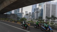 Pengendara melintasi kawasan jalan Sudirman yang lengang di Jakarta, Minggu (27/6/2021). 