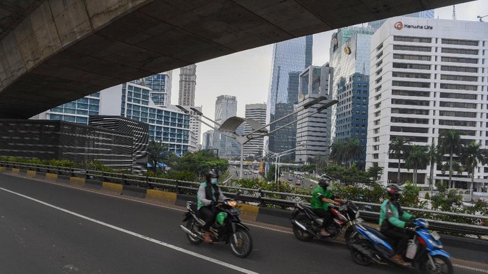 ANTISIPASI PENYEBARAN COVID-19 Pengendara melintasi kawasan jalan Sudirman yang lengang di Jakarta, Minggu (27/6/2021). Pembatasan kegiatan oleh pemerintah melalui PPKM Mikro hingga 5 Juli 2021 antara lain penutupan ruang publik, pembatasan operasional transportasi serta penerapan protokol lebih ketat diharapkan dapat mengurangi penyebaran COVID-19 dimana fasilitas kesehatan telah penuh dalam menghadapi lonjakan pasien terkonfirmasi COVID-19. ANTARA FOTO/Wahyu Putro A/aww.