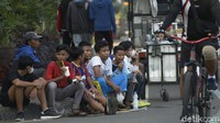 Remaja terlihat abai terhadap protokol kesehatan (prokes), tanpa mengenakan masker dan berkerumun. Mereka justru asyik melepas masker dan menikmati jajanan di pinggir jalan.