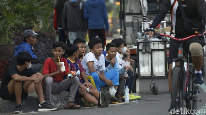 Duh, Anak-anak di Bekasi Ini Santuy Banget Nggak Pake Masker! Para remaja tertangkap kamera sedang menikmati suasana pagi dengan berkerumun tanpa bermasker di kawasan Stadion Patriot Chandrabaga Kota Bekasi, Minggu (27/06/2021). Pemandangan ini kontras dengan lonjakan kasus Covid-19 dalam beberapa hari terakhir.