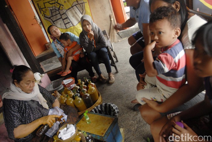Pembuat jamu  godogkan atau jamu tradisional melayani pembeli di warungnya, Kadipiro, Surakarta, Jawa Tengah, Selasa (3/10). Simbah pembuat jamu godogan tersebut sudah melayani pembeli sejak tahun 60an dimasa pemerintahan presiden Soekarno.  Jamu tradisional ini juga digemari Joko Widodo semasa menajdi walikota Surakarta hingga sekarang. Setiap harinya pedagang mampu menjual sekitar 1000 gelas perharinya dengan harga 2000 pergelas.
