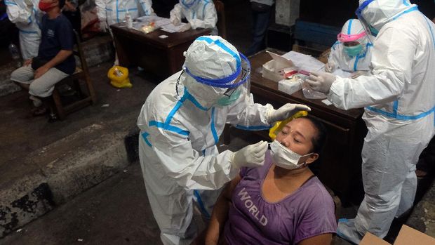 Petugas kesehatan mengambil sampel tes cepat Antigen dari sejumlah pedagang saat pelacakan COVID-19 di Pasar Kreneng, Denpasar, Bali, Rabu (23/6/2021). Pemerintah Kota Denpasar gencar menggelar tes cepat Antigen di tempat-tempat yang berpotensi menimbulkan kerumunan untuk menekan penularan COVID-19 saat situasi kasus positif meningkat sejak seminggu terakhir di wilayah itu. ANTARA FOTO/Nyoman Hendra Wibowo/rwa.