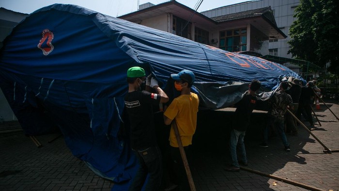 Relawan membangun tenda barak di Rumah Sakit Umum Pusat Dr. Sardjito, Sleman, DI Yogyakarta, Minggu (27/6/2021). Pembangunan tenda barak tersebut untuk melakukan screening dan penampungan sementara pengunjung di Instalasi Gawat Darurat (IGD) agar tidak terjadi kerumunan serta  mengantisipasi penularan COVID-19. ANTARA FOTO/Hendra Nurdiyansyah/foc.