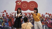 Di China warga berpose di pameran foto yang menampilkan kehidupan masyarakat di bawah partai komunis dari tahun 1921 hingga 2021 yang dipajang di distrik perbelanjaan Wangfujing di Beijing. AP/Andy Wong