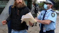 Petugas kepolisian mengamankan pengunjuk rasa di sela-sela pengumuman resmi lockdown. Ya, tidak di Indonesia tidak di Australia, ada saja yang memprotes keputusan pemerintah terkait penanganan Corona ini.
