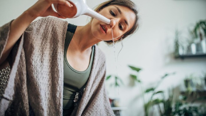 Cuci hidung One woman, young lady using neti pot at home.
