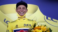 Senyum kebahagiaan tidak bisa disembunyikan dari pria berusia 26 tahun tersebut saat naik podium . Van Der Poel langsung mengenakan yellow jersey sebagai pebalap dengan akumulasi waktu tercepat. AP Photo/Stephane Mahe.