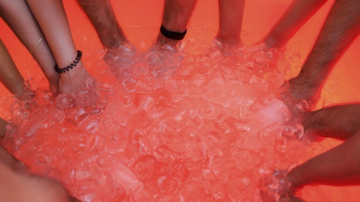 Participants put their hands in the ice during an ice bath therapy session at the desert near Sharjah, United Arab Emirates, June 25, 2021. Picture taken June 25, 2021. REUTERS/Rula Rouhana