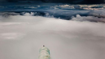 Seorang pendaki berdiri di puncak gunung di Islandia. Foto: Brightside