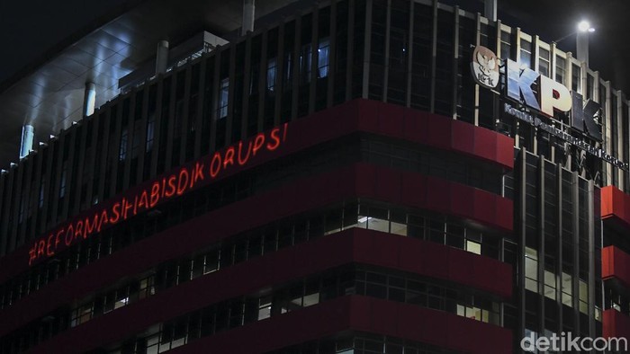 Pedagang menyaksikan proyeksi bertuliskan #mositidakpercaya saat aksi oleh aktivis Greenpeace di Gedung Merah Putih KPK, Jakarta, Senin (28/6/2021). Aksi tersebut menyuarakan keadilan bagi 51 pegawai KPK yang dinonaktifkan akibat dinyatakan tidak lulus Tes Wawasan Kebangsaan, juga menyampaikan pesan untuk menyelamatkan lembaga anti korupsi dari cengkraman oligarki. ANTARA FOTO/Galih Pradipta/foc.