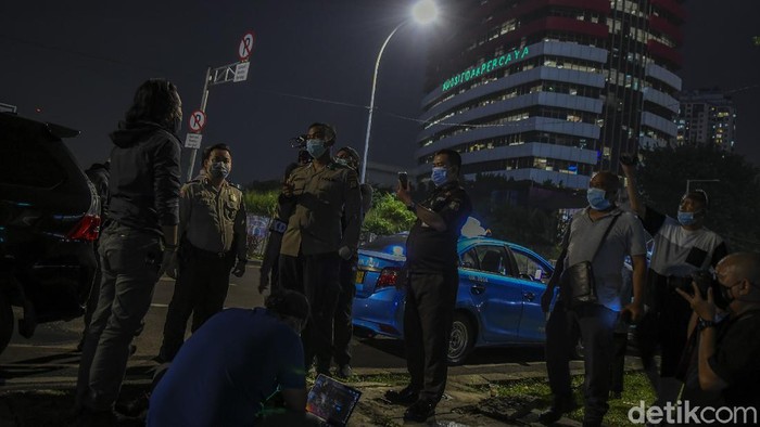 I GEDUNG KPK Pedagang menyaksikan proyeksi bertuliskan #mositidakpercaya saat aksi oleh aktivis Greenpeace di Gedung Merah Putih KPK, Jakarta, Senin (28/6/2021). Aksi tersebut menyuarakan keadilan bagi 51 pegawai KPK yang dinonaktifkan akibat dinyatakan tidak lulus Tes Wawasan Kebangsaan, juga menyampaikan pesan untuk menyelamatkan lembaga anti korupsi dari cengkraman oligarki. ANTARA FOTO/Galih Pradipta/foc.