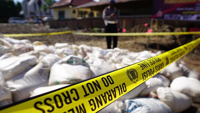 MINUMAN KERAS DI GORONTALO Anggota Polri menjaga karung dan plastik berisi minuman keras jenis captikus pada pemusnahan barang bukti hasil sitaan di Polres Gorontalo Kota, Kota Gorontalo, Gorontalo, Selasa (29/6/2021). Satnarkoba Polres Gorontalo Kota memusnahkan 4.600 liter captikus hasil sitaan pada bulan Mei 2021 sebagai salah satu upaya pemberantasan peredaran minuman keras di wilayah itu. ANTARA FOTO/Adiwinata Solihin/nz