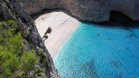 Pantai Navagio di Yunani dikenal juga dengan sebutan Pantai Kapal Karam karena pada 1983 ada kapal pengangkut rokok yang kecelakaan di sana. Pantai ini punya tebing indah yang cocok diabadikan sebagai latar foto. Foto: Wikimedia Commons
