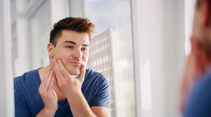 Morning hygiene, Handsome man in the bathroom looking in mirror