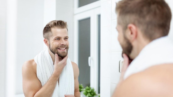 Morning hygiene, Handsome man in the bathroom looking in mirror
