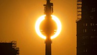 Matahari tenggelam terlihat di belakang menara televisi di Berlin, Jerman (27/6/2021).  Gelombang panas menerpa di sejumlah wilayah Jerman dalam beberapa hari belakangan. Christophe Gateau/dpa via AP.