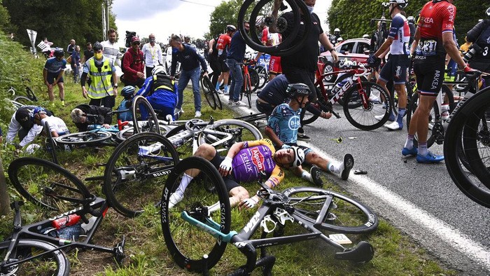 Berdarah-darah Demi Finish Pertama di Tour de France Italy's Kristian Sbaragli, left, and France's Bryan Coquard, right, lie on the ground after crashing during the first stage of the Tour de France cycling race over 197.8 kilometers (122.9 miles) with start in Brest and finish in Landerneau, France, Saturday, June 26, 2021. (Anne-Christine Poujoulat, Pool Photo via AP)