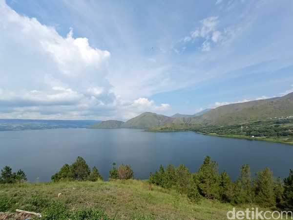 Latar Danau Toba yang sangat indah membuat wisatawan terkagum-kagum. 