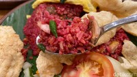 Meski warnanya merah menyala, tapi rasanya tidak pedas sama sekali. Lebih dominan gurih sedap dari suwiran daging ayam dan bahan lainnya di nasi goreng ini. Tekstur nasi gorengnya juga tipe yang pulen, bukan yang ‘pera’ seperti nasi goreng di pinggir jalan.  Foto: detikFood