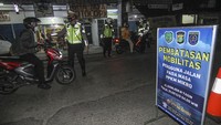 Petugas menghentikan pengendara yang masih melintas saat pembatasan mobilitas di jalan Komjen M Yasin, Depok, Jawa Barat, Selasa (29/6/2021). Pemkot pun memutuskan membatasi sejumlah kegiatan masyarakat. ANTARA FOTO/ASPRILLA DWI ADHA.