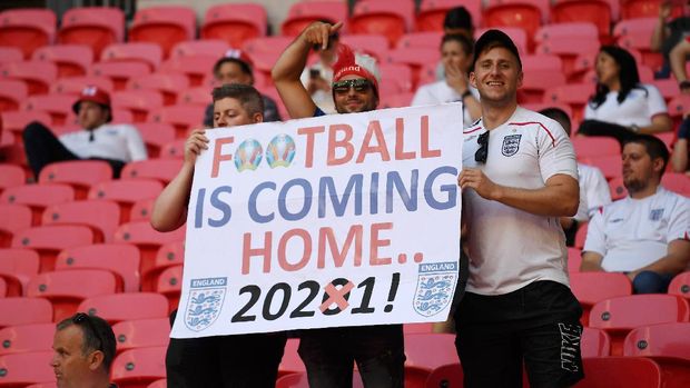 LONDON, ENGLAND - JUNE 13: England fans with a sign saying Football is coming home 2021 prior to the UEFA Euro 2020 Championship Group D match between England and Croatia at Wembley Stadium on June 13, 2021 in London, England. (Photo by Andy Rain - Pool/Getty Images)