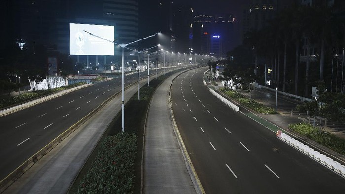 Suasana malam jalan yang terlihat sepi di  kawasan Sudirman, Jakarta, Rabu (12/5/2021) malam. Polda Metro Jaya memberlakukan crowd free night untuk mencegah kerumunan takbir keliling di malam Idul Fitri 1442 yang berlaku mulai pukul 22:00 malam ini  untuk mencegah penularan COVID-19.  ANTARA FOTO/ Reno Esnir/hp.