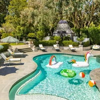 Area outdoor terasa seperti resor dengan halaman hijau nan asri dan kolam renang berbentuk danau. (Foto: Architectural Digest/Laure Joliet)