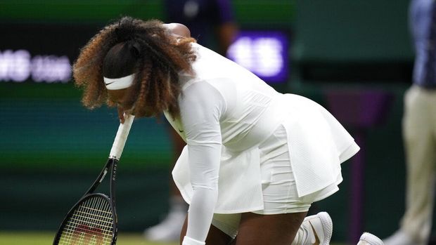 Serena Williams of the US falls to the ground during the women's singles first round match against Aliaksandra Sasnovich of Belarus on day two of the Wimbledon Tennis Championships in London, Tuesday June 29, 2021. (AP Photo/Kirsty Wigglesworth)