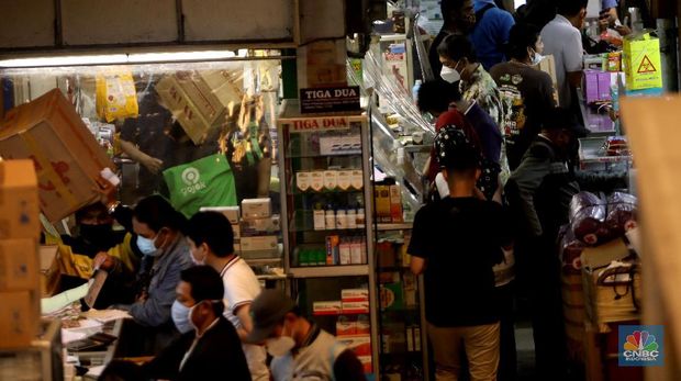 Pedagang melayani pengunjung di Pasar Pramuka, Jakarta, Rabu (30/6/2021). Tingginya kasus positif Covid-19 di Jakarta membuat penjualan alat kesehatan, obat, dan vitamin di Pasar Pramuka meningkat hingga 100 persen. Salah satu pedagang di Pasar Pramuka mengatakan untuk obat-obatan vitamin paling banyak di konsumsi. Iya mengatakan vitamin C yang banyak dibeli karena dianggap mampu meningkatkan imunitas tubuh di masa pandemi. Meski banyaknya permintaan, para pedagang pasar tidak menaikkan harga. Harga jual vitamin yang berkisar mulai dari Rp30 ribu hingga di atas Rp100 ribu. (CNBC Indonesia/ Muhammad Sabki)