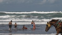 Para pengunjung pantai Parangtritis itu terlihat asyik bermain air di bibir pantai. 